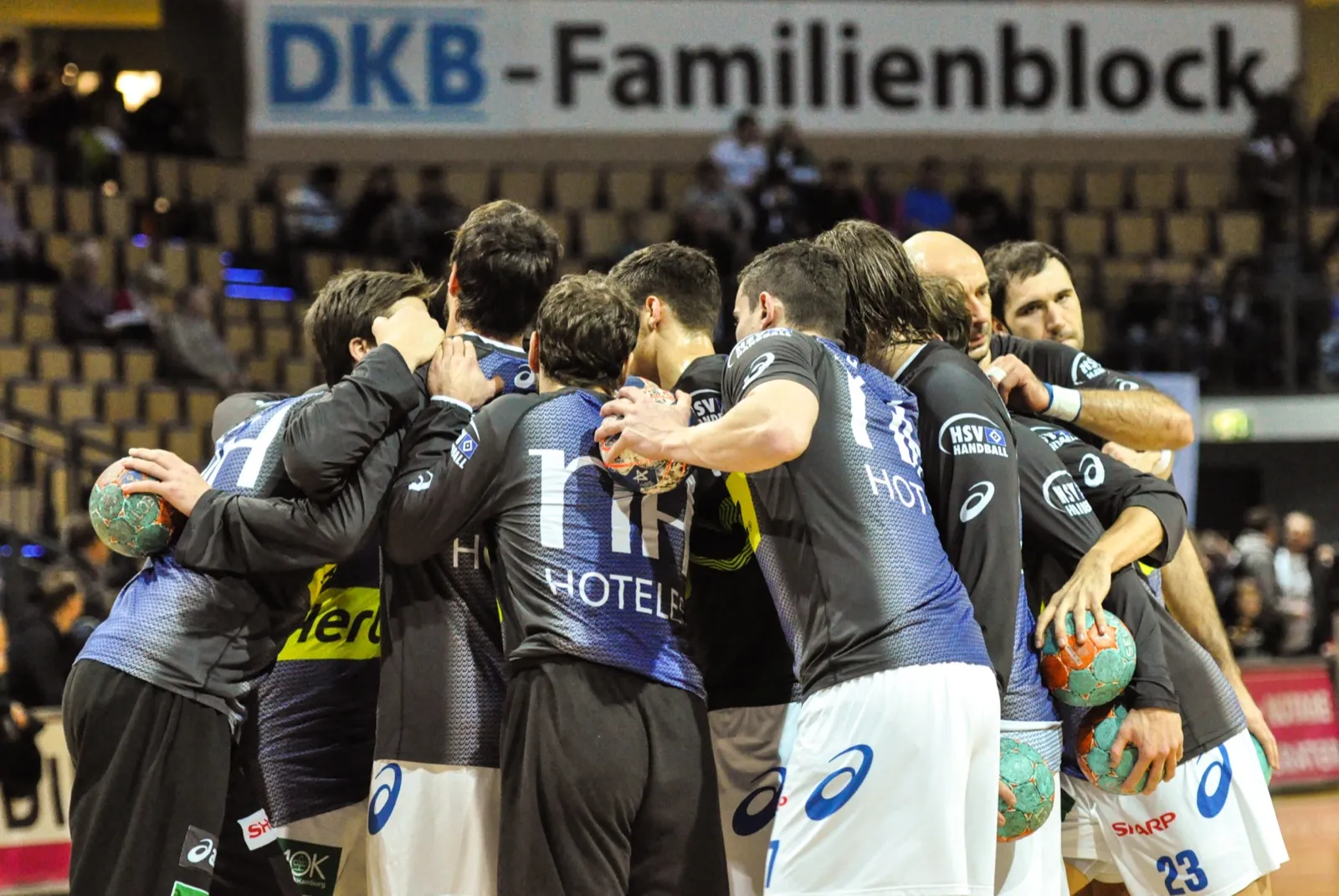 Handball team huddling together before throw-off